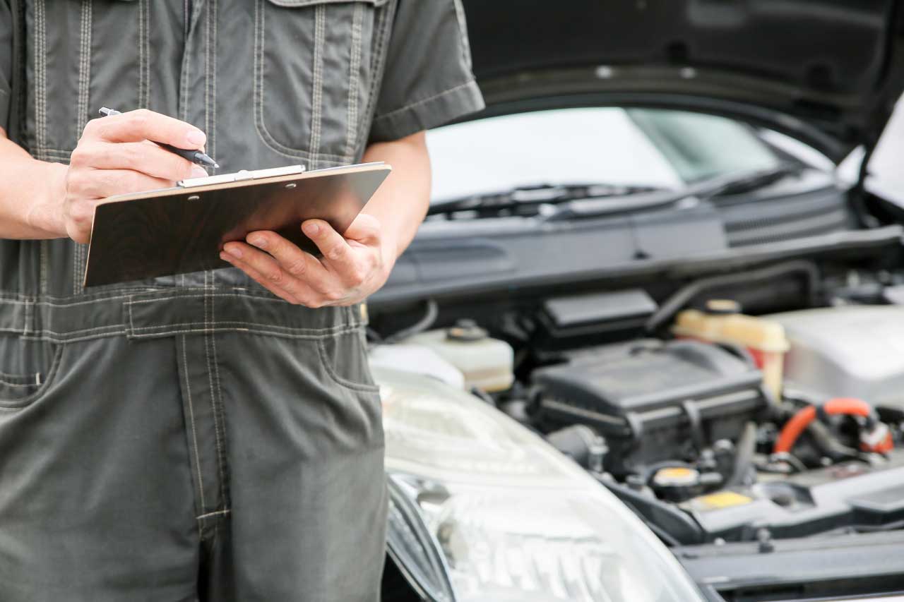 自動車整備士がチェック表を記入する風景